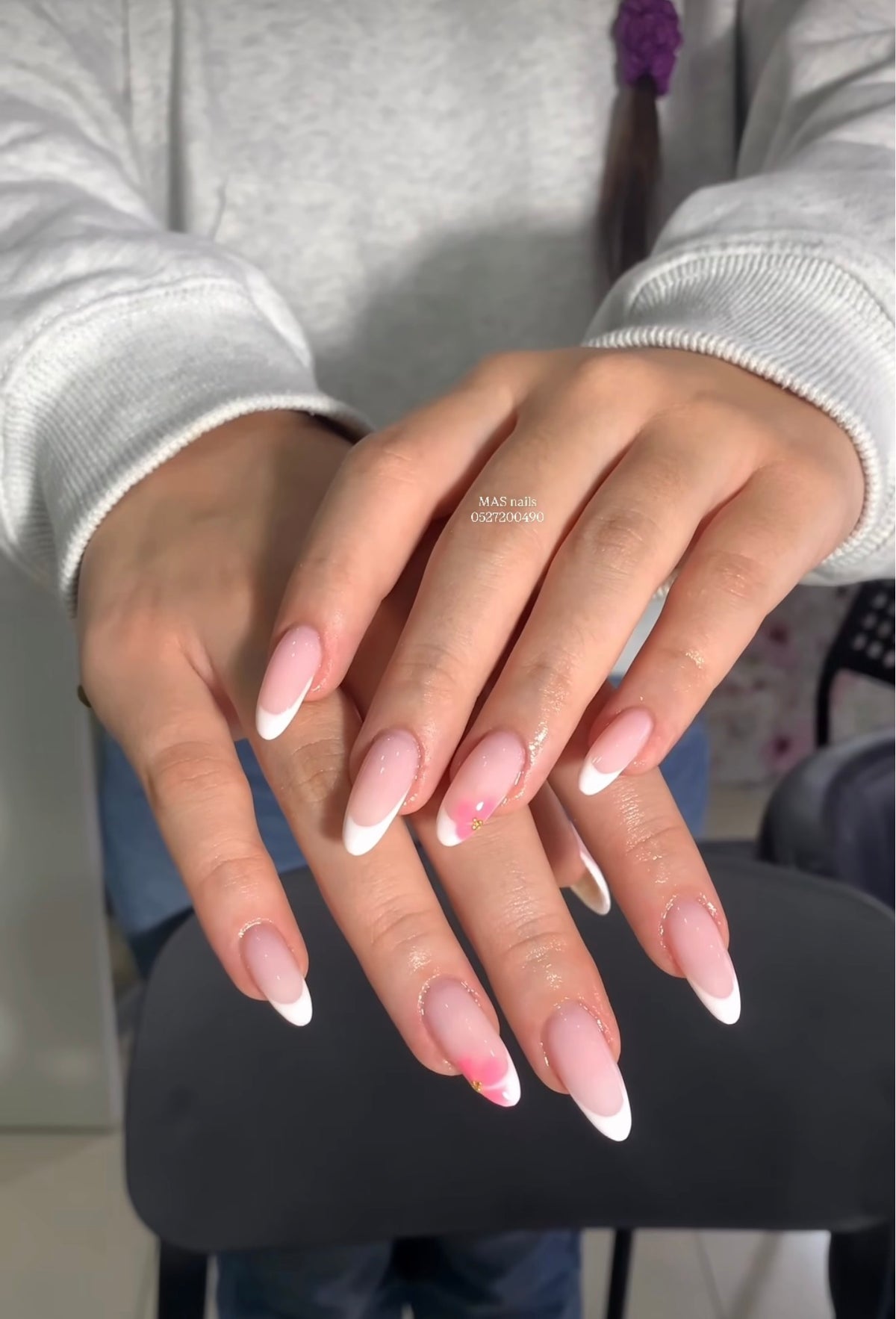 Almond shaped French tip nail extensions featuring pink blooming gel flower nail art at Mas Nails Salon Dubai
