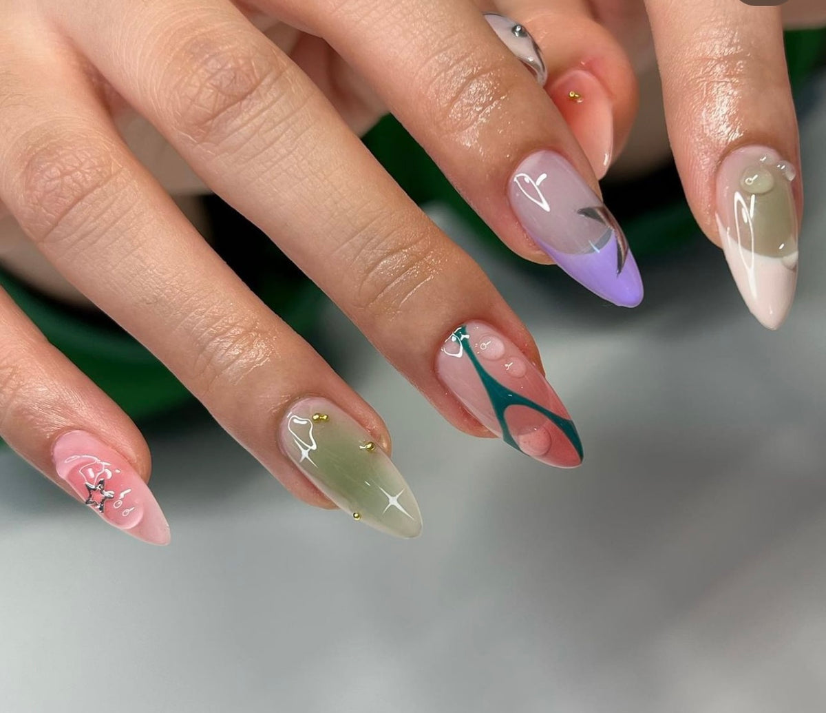 Hand-painted custom 3D nail art extensions with gel swirl designs and chrome accents at Mas Nails Salon Dubai